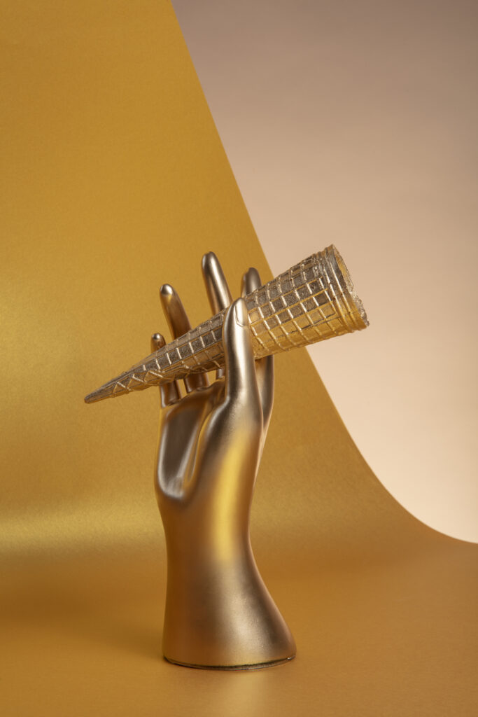 gold aesthetic wallpaper with hand holding cone