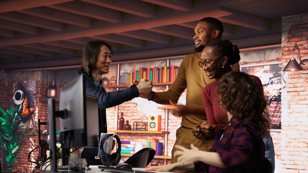 startup team cheering after seeing company stocks raising, doing high five